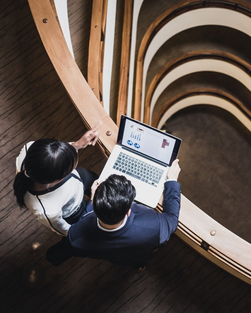 Deux professionnels analysant des données sur ordinateur portable lors d’un rendez-vous business. Avec Sincrone IT : renforcer sa cybersécurité et mener des actions de prévention des cyberattaques