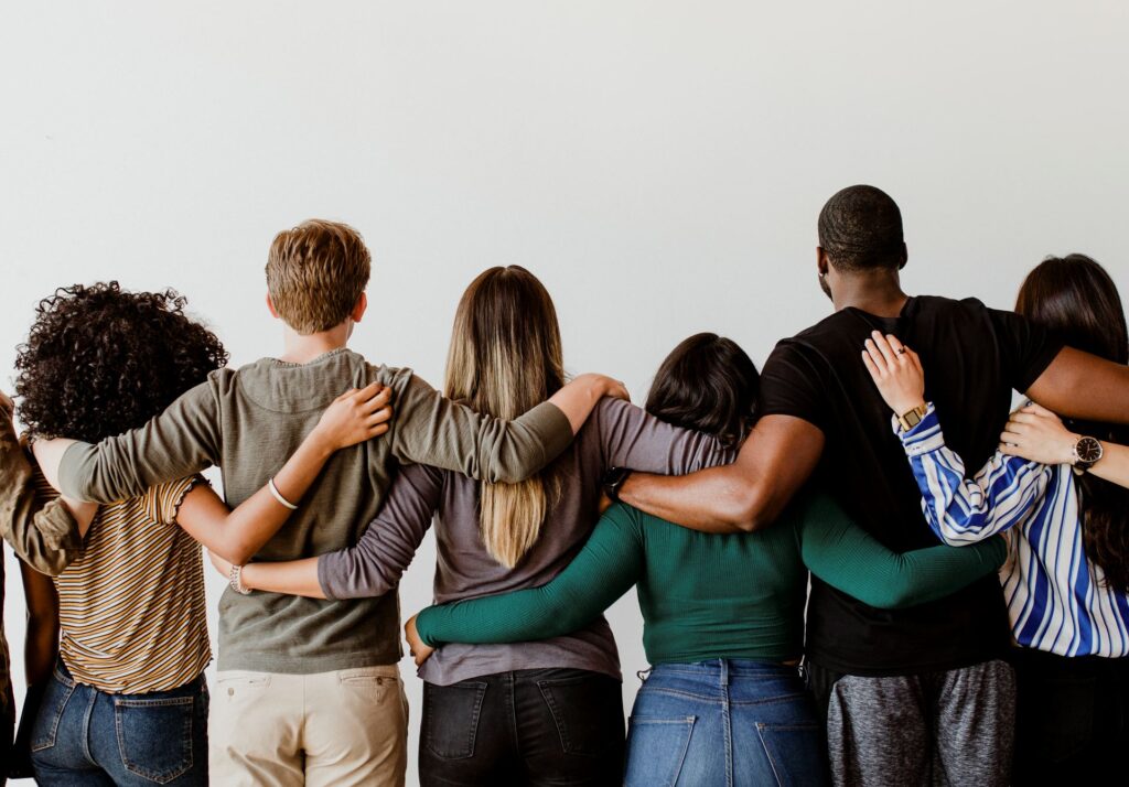 Groupe de personnes de dos, bras autour des épaules, symbolisant l’unité et l’esprit d’équipe. Sincrone IT compte 95 collaborateurs engagés au quotidien : Ingénieurs, techniciens, commerciaux, fonctions support… une équipe soudée à votre service en France.