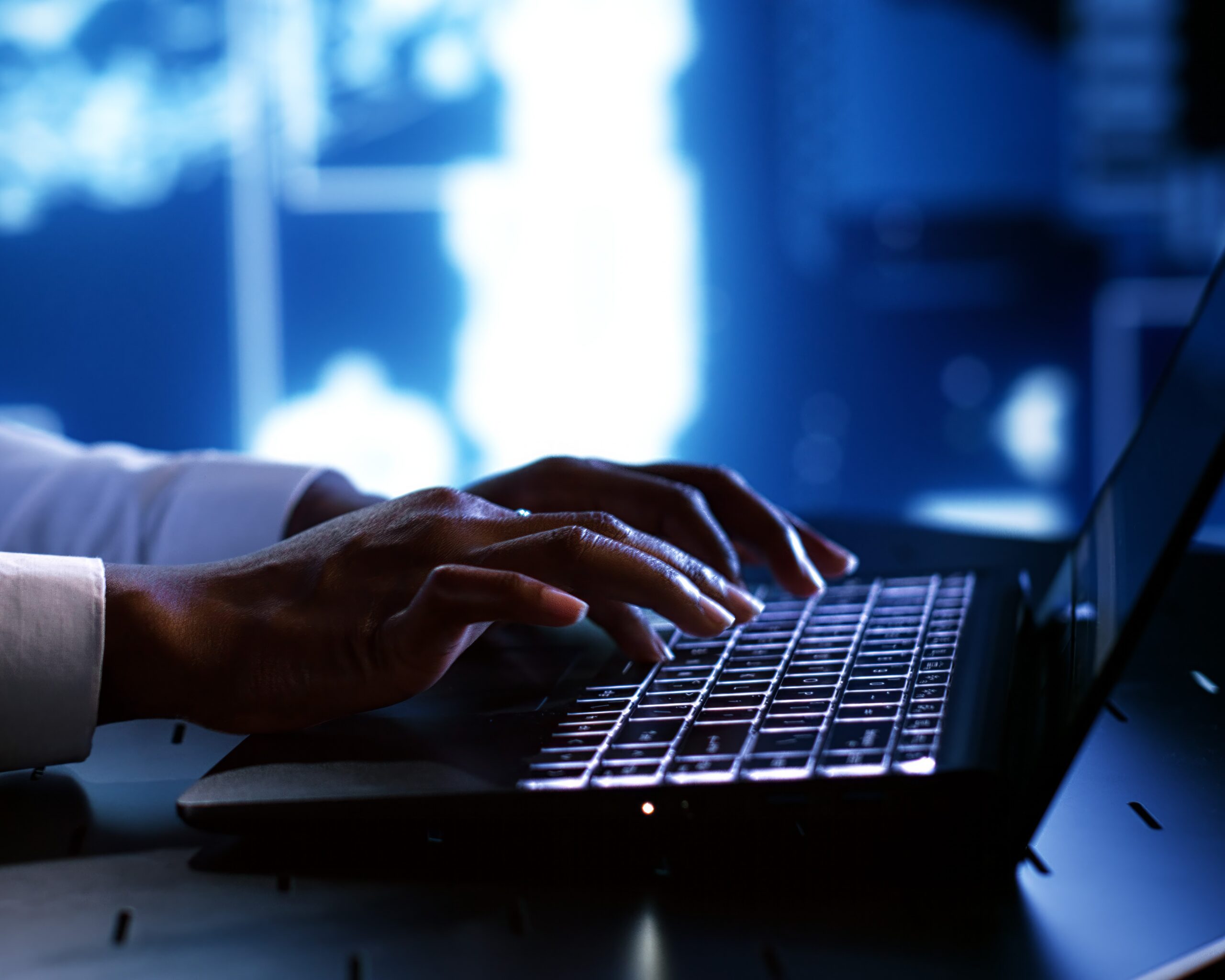Mains de femme en train de taper sur son clavier d'ordinateur.