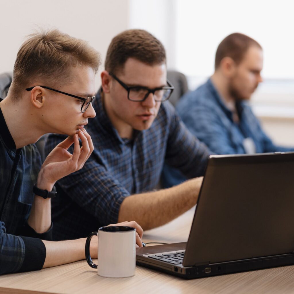collaborateurs d'une entreprises qui suivent une formation de cybersécurité devant un ordinateur portable en etreprise.